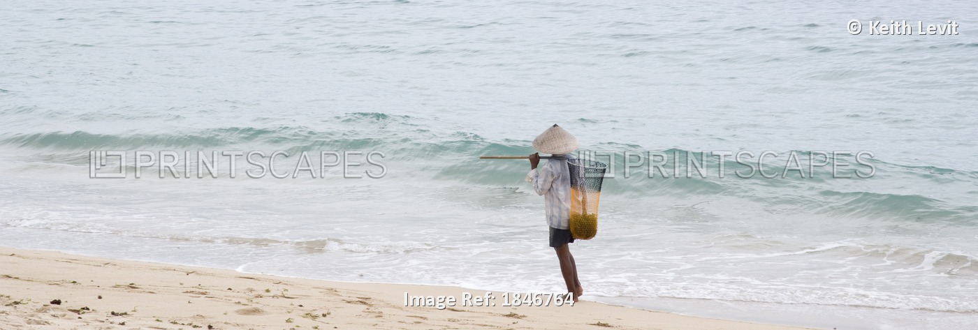 Person Walking On The Beach With A Fishing Net; Bali,Indonesia