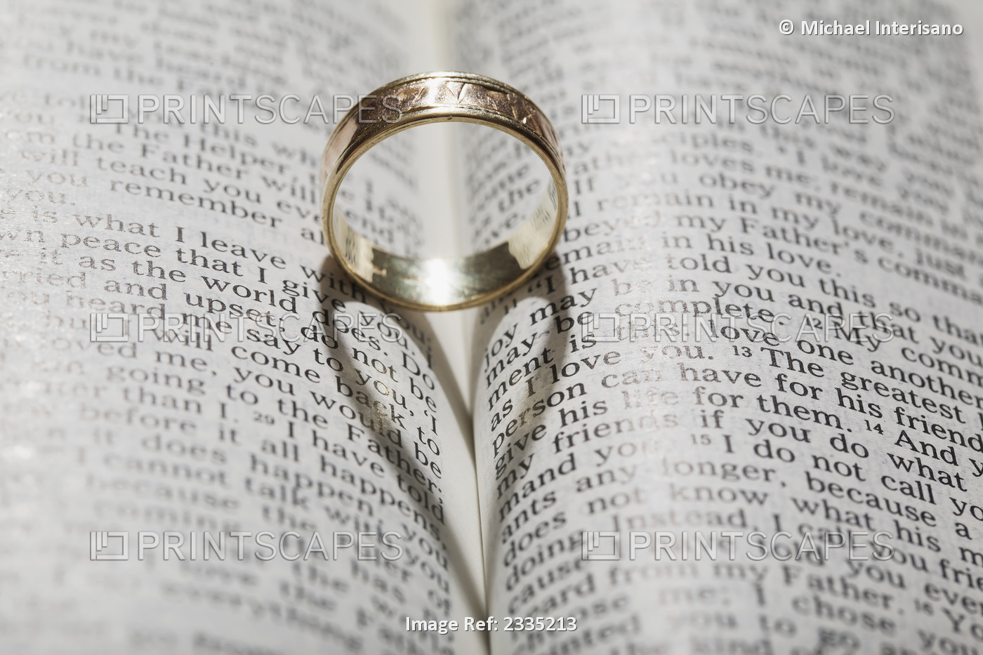 Close up of a gold ring with the shadow of an heart on book about love;Calgary ...