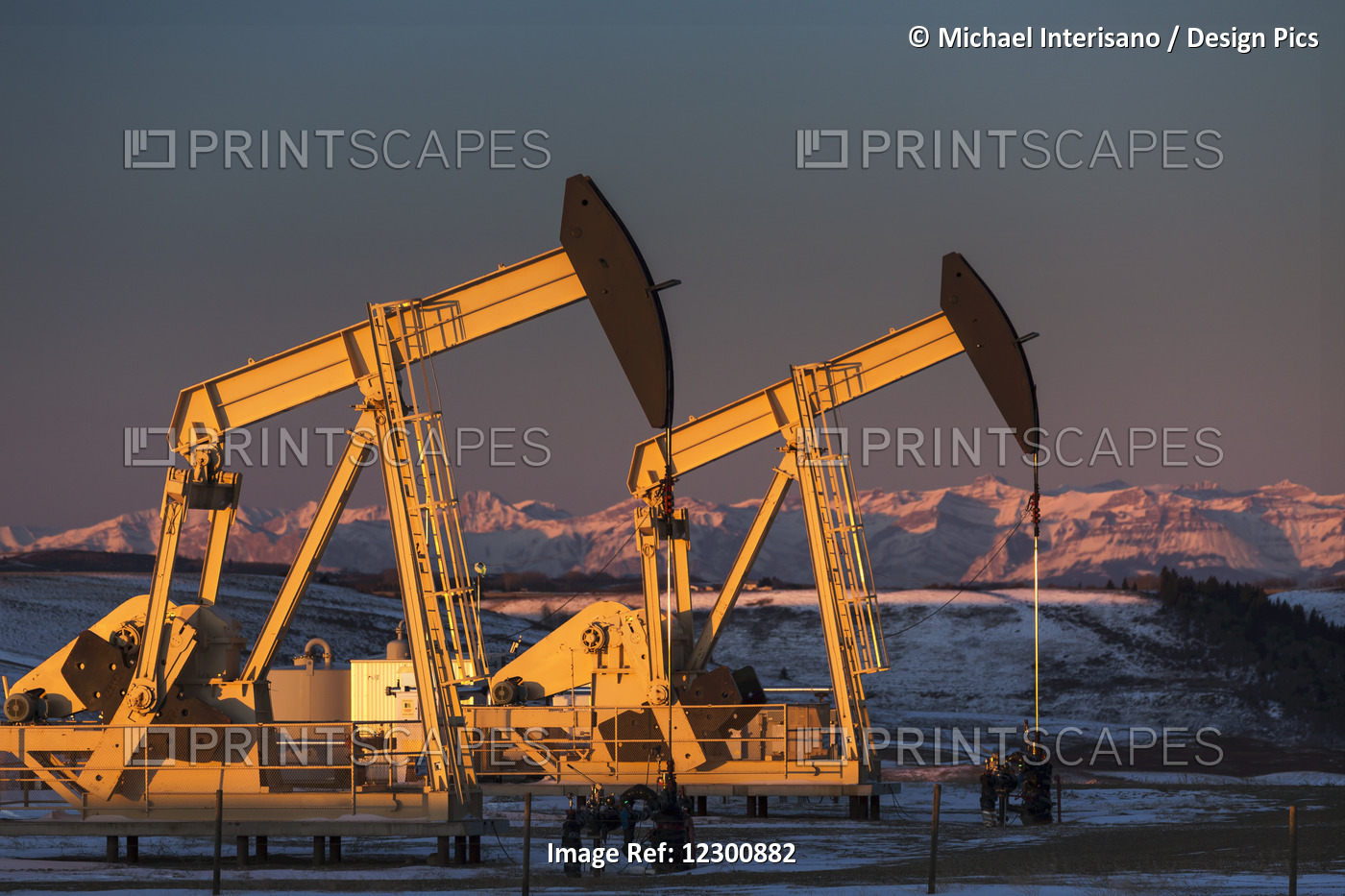 Two Pump Jacks At Sunrise Reflecting The Warm Morning Light In A Snow Covered ...