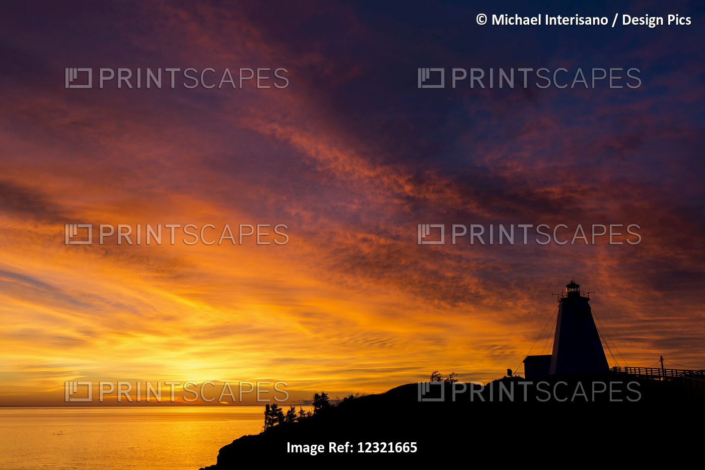 Silhouette Of A Lighthouse On A Cliff Overlooking A Colourful Reflected Body Of ...